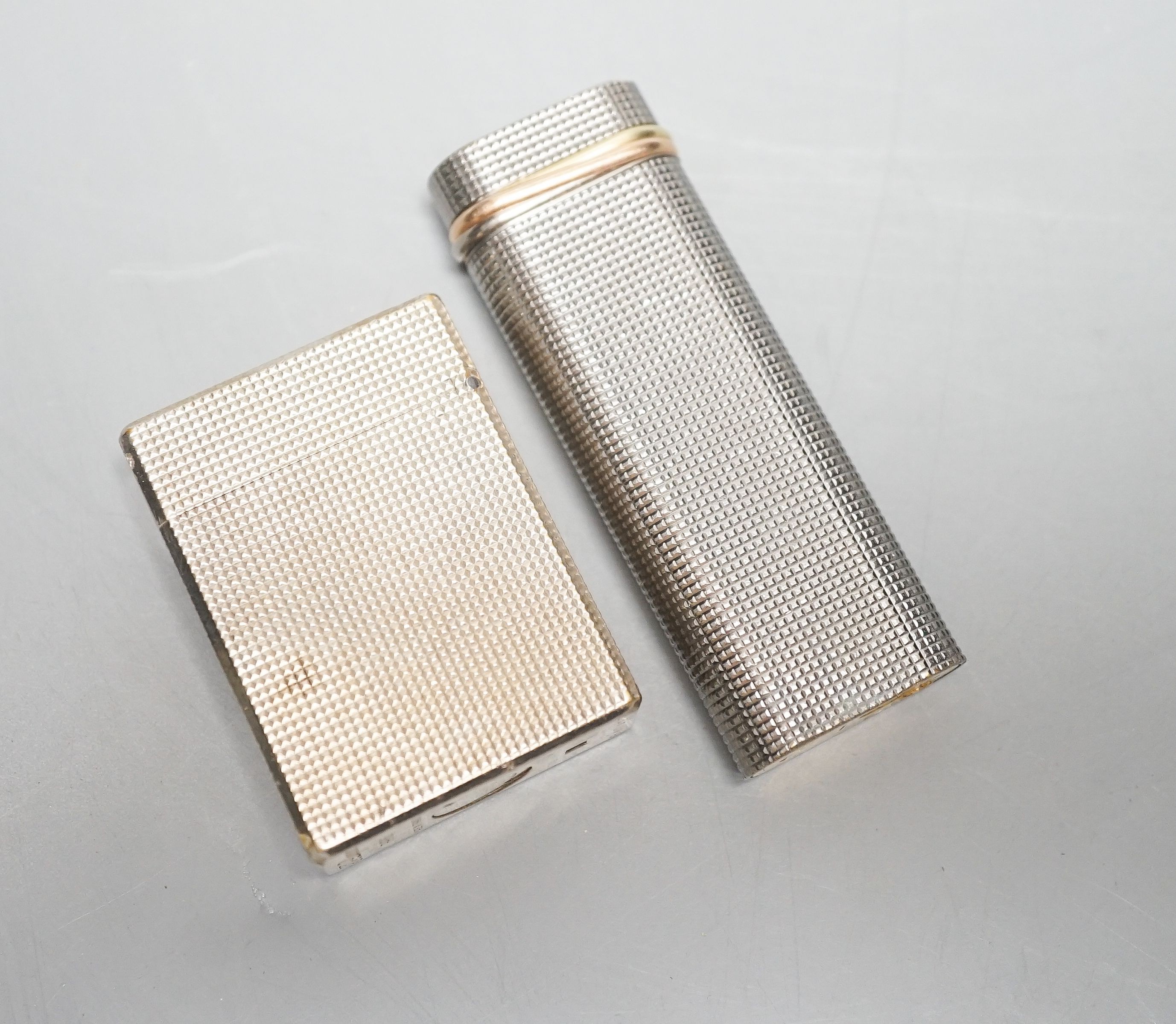 A Cartier engine turned lighter and a similar cased Dupont lighter